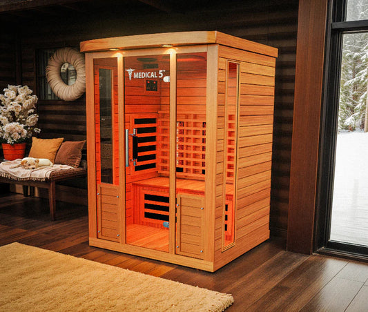 Wooden infrared sauna in a room with a window showing a snowy landscape.