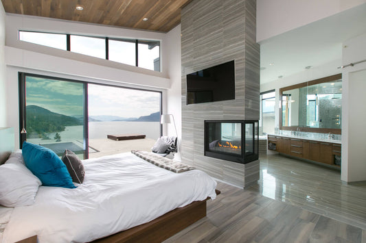 Modern bedroom and living space featuring the Napoleon Ascent Multi-View 3-sided peninsula gas fireplace with expansive views.