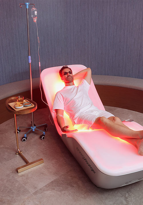 Person relaxing on the EnergyLounger in a luxury wellness room.