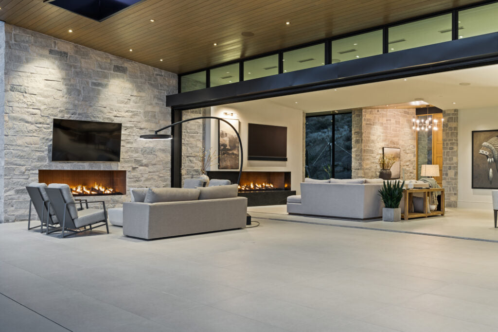 Bromic Eclipse heater in a covered outdoor patio with fireplace and lounge seating