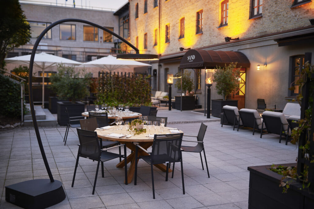 Commercial patio with tables and Bromic Eclipse heater providing ambient lighting