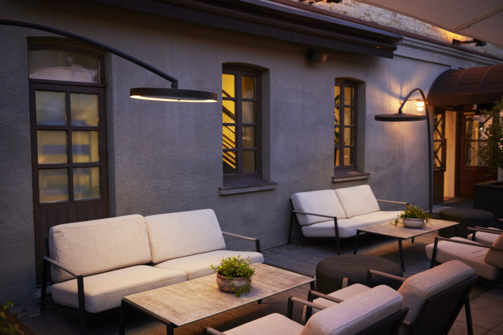 Eclipse heater beside outdoor seating area attached to a stucco home