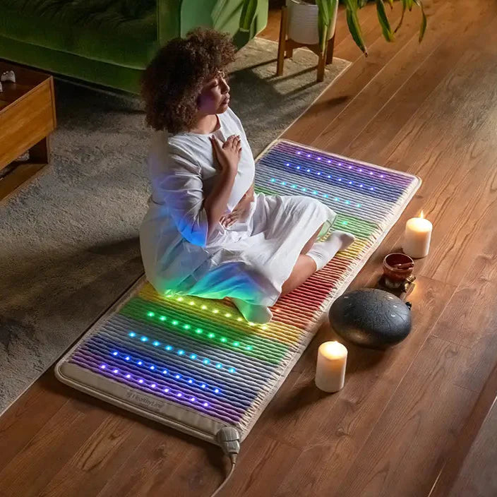 Person relaxing on HealthyLine Rainbow Chakra Mat 7428 during yoga/meditation session