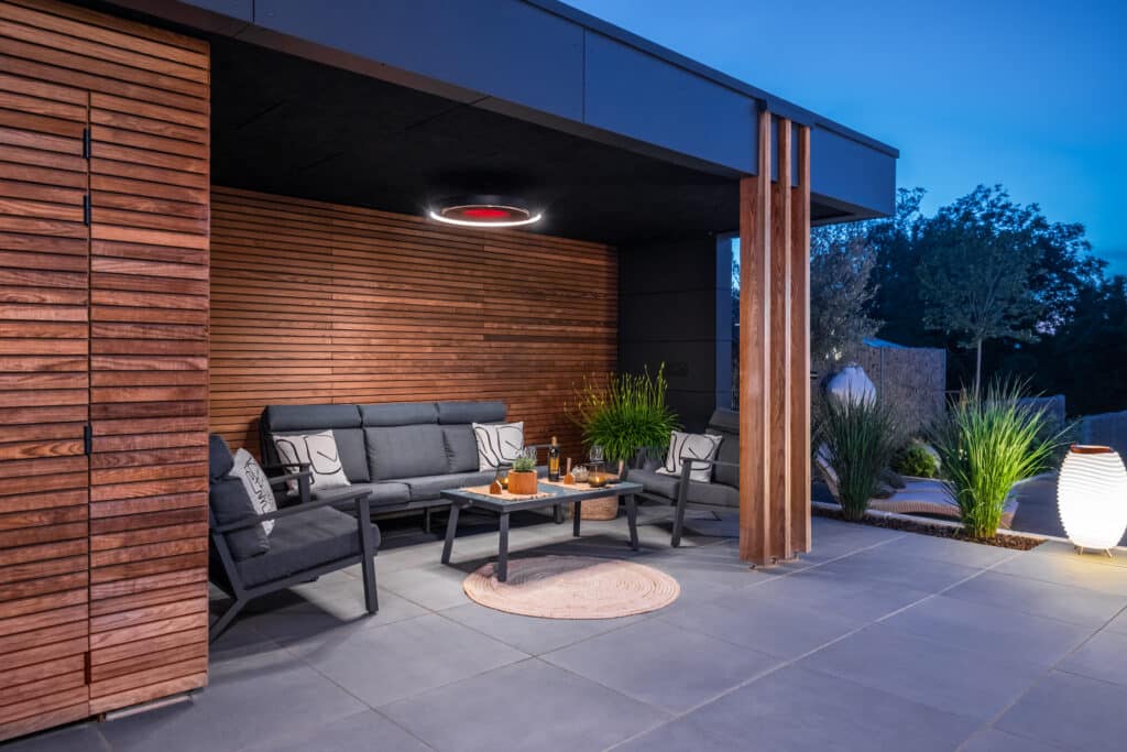 Outdoor patio area with modern furniture and wooden walls.