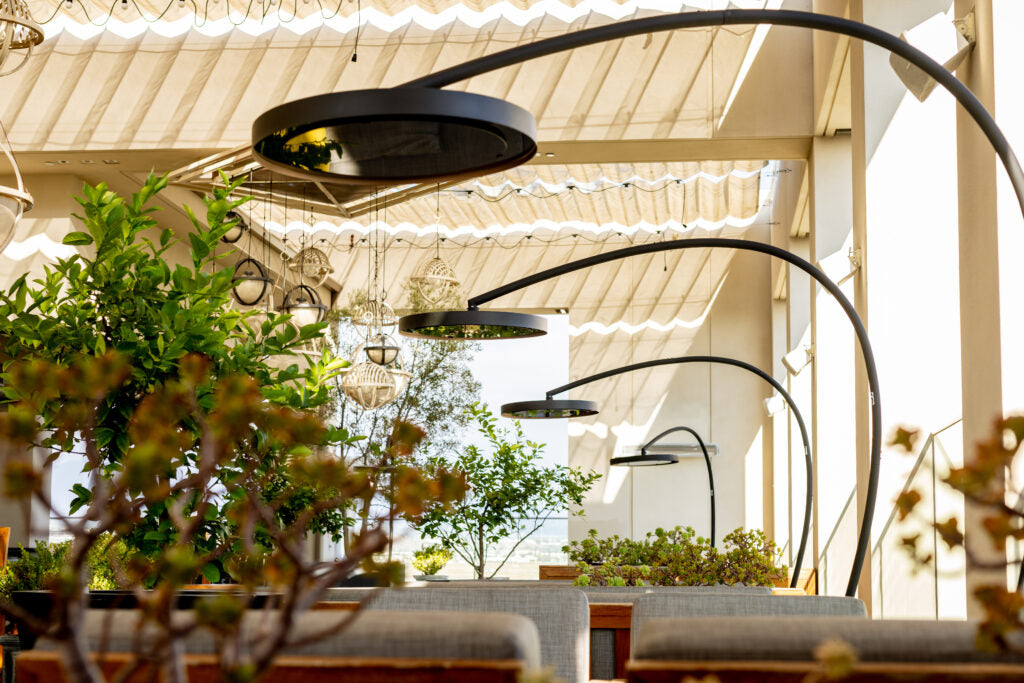 Bromic Eclipse heater in a residential garden patio with plants and lounge seating