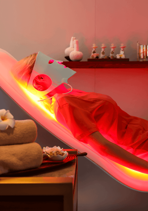 Close-up view of a user lying on the EnergyLounger during an active red and near-infrared light therapy session.