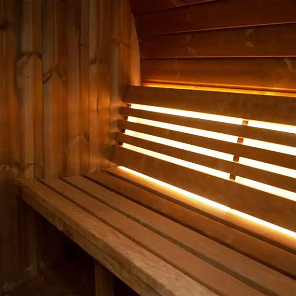 Interior of the SaunaLife E6 showing warm LED bench lighting illuminating the Thermo-Spruce wood walls.