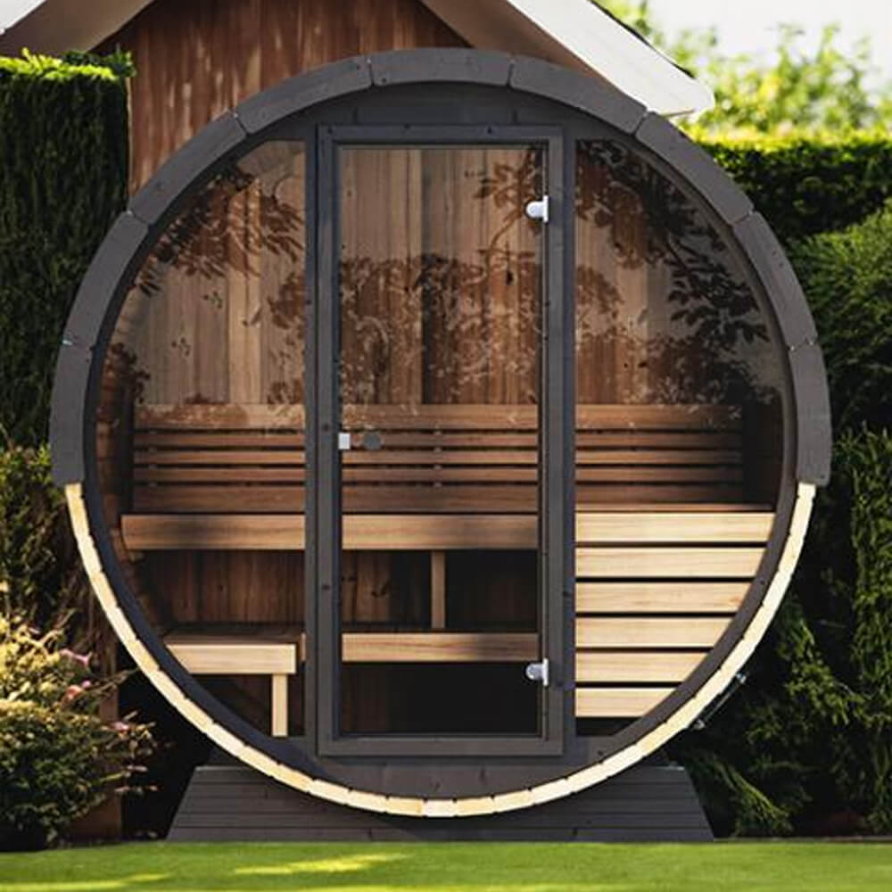 SaunaLife EE6G 4-person outdoor barrel sauna placed in a landscaped backyard with full-glass front wall and Thermo-Spruce exterior